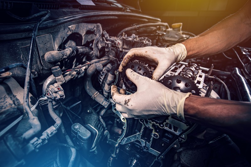 Mechanic repairing car engine with tools