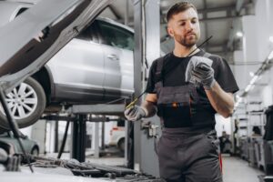 Car mechanic checking the engine oil level in the service center