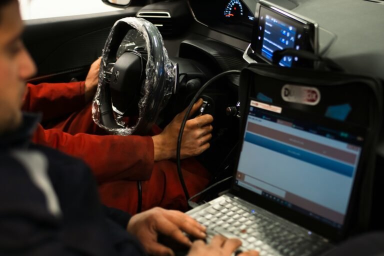 A man sitting in a car using a laptop computer